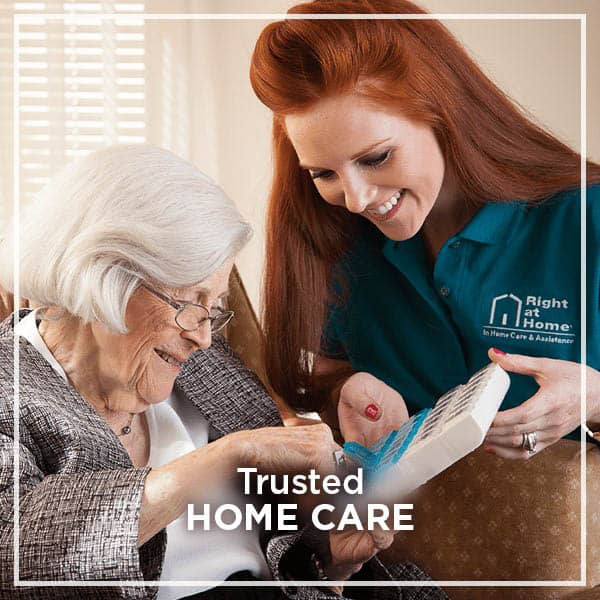 Caregiver assisting elderly woman in a cozy setting.