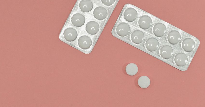 Packs of medication on a pink background.