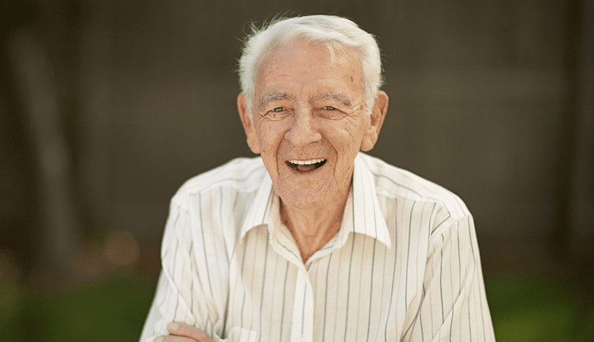 Smiling elderly man sitting outdoors