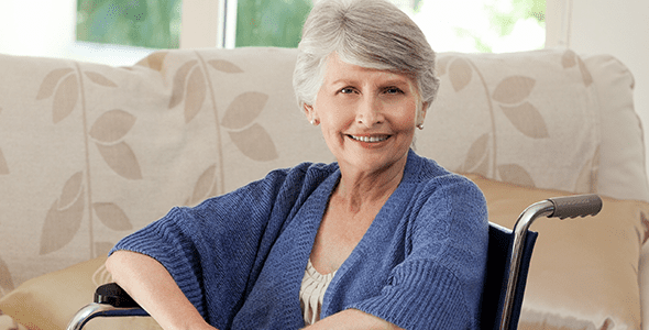 Smiling elderly woman in a wheelchair indoors