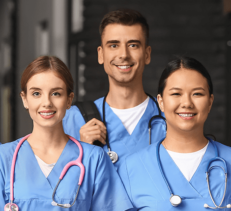 Three healthcare professionals in scrubs smiling