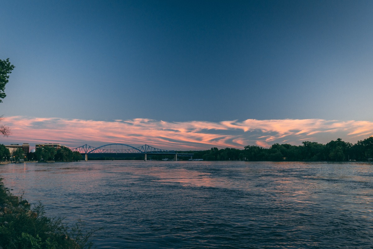 Scenic view of a river at sunset with clouds.