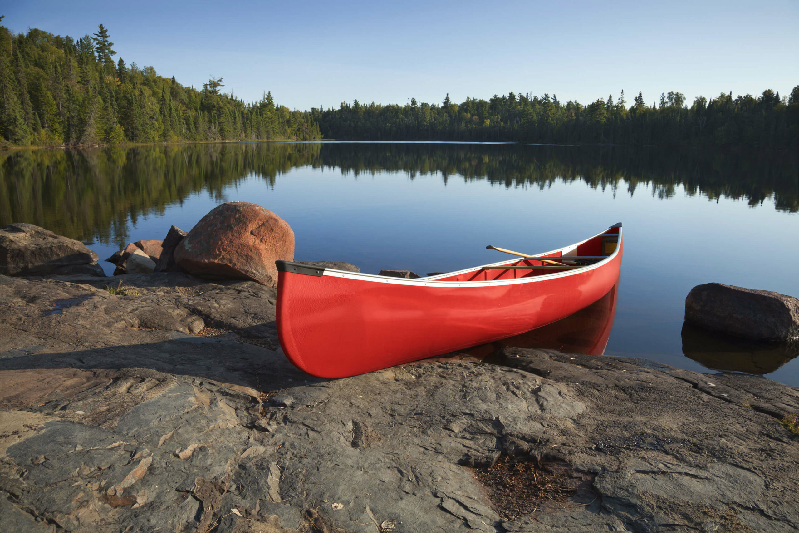 Red canoe by a peaceful lake