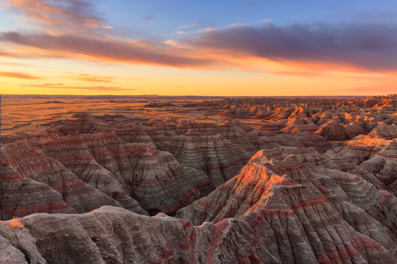 Scenic landscape at sunset with layered rock formations.