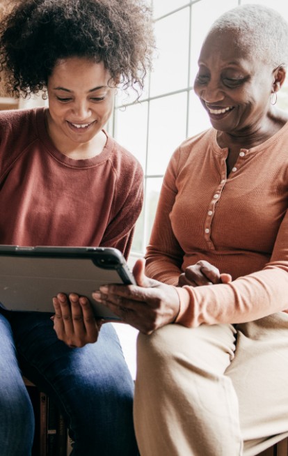 Two women enjoying a moment together with a tablet.
