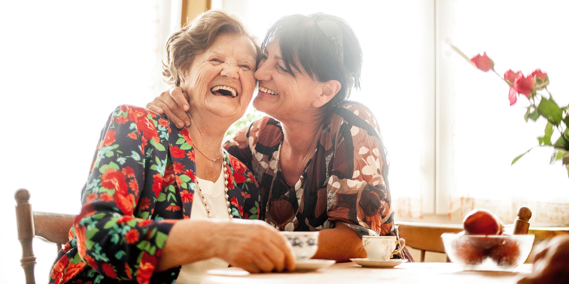 Two women laughing together at a table