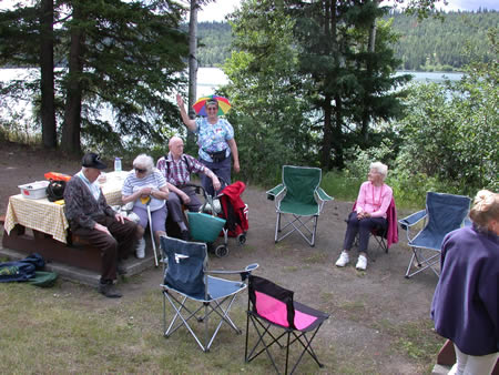 Seniors enjoying a gathering outdoors by a lake