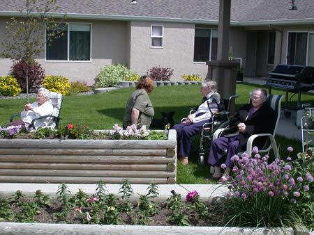 Residents enjoying the outdoor space with flowers and plants.