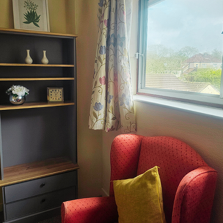 Cozy corner in a resident room with a chair and decor.