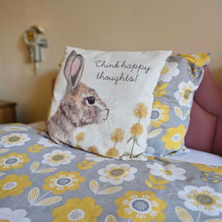 Cozy bed with decorative pillow featuring a rabbit