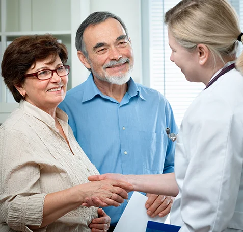 Doctor interacting with elderly couple in consultation