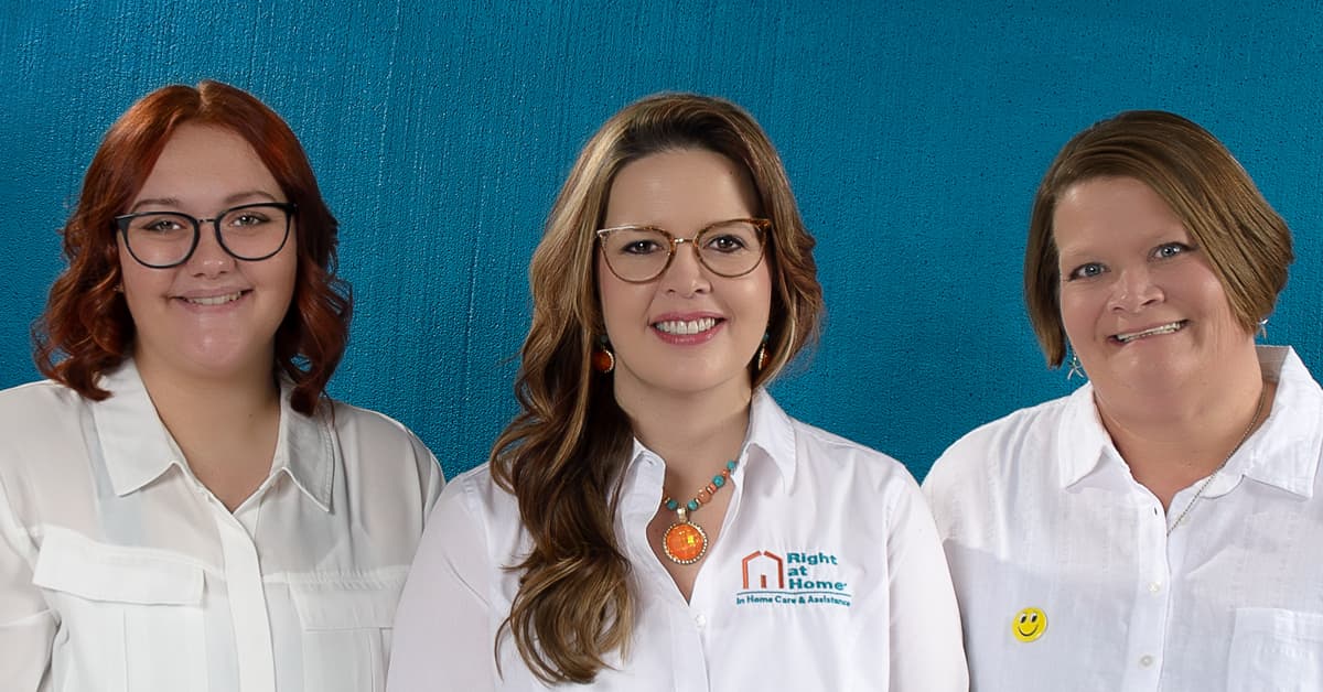 Three staff members smiling together.