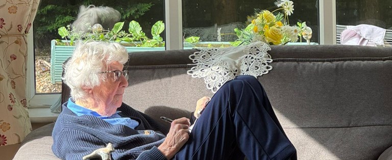An elderly resident relaxing on a couch.