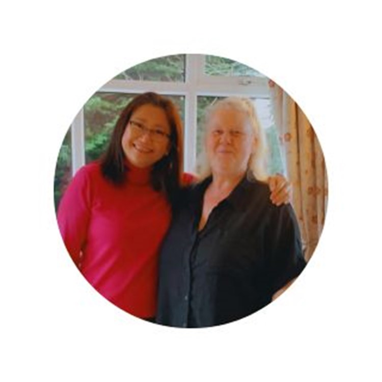 Resident and staff member smiling together inside