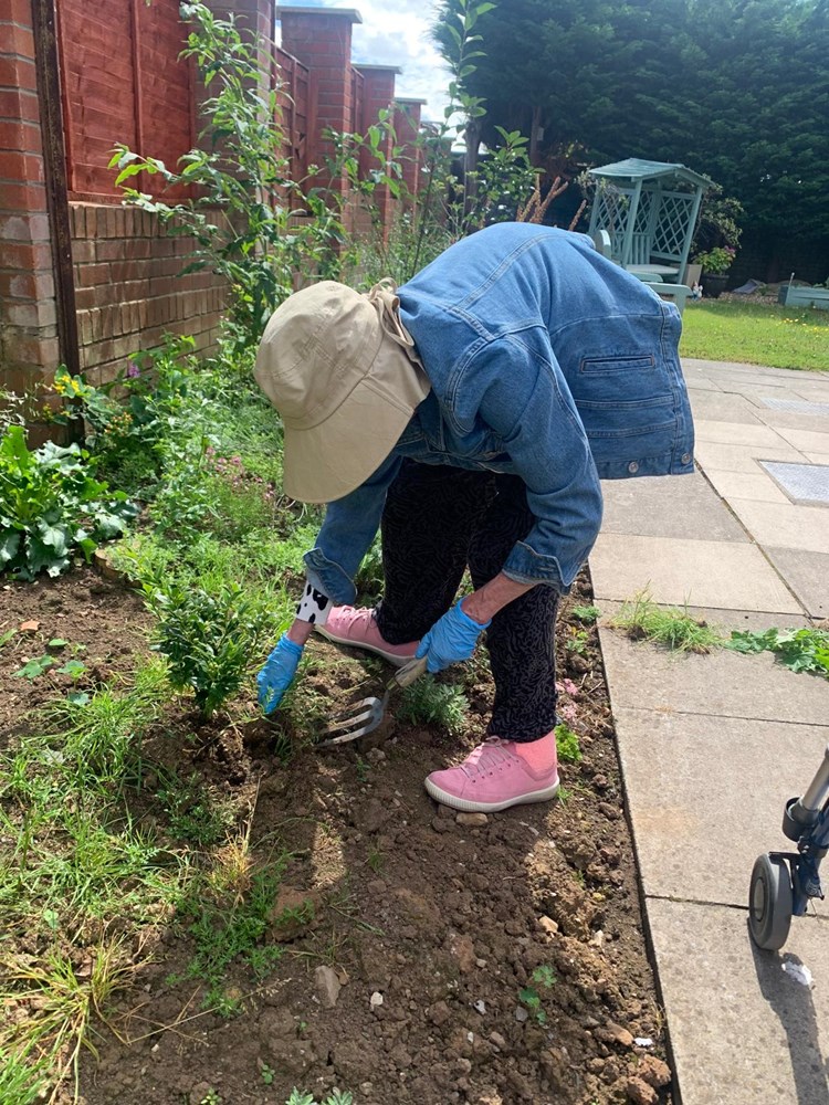Resident gardening in outdoor space.