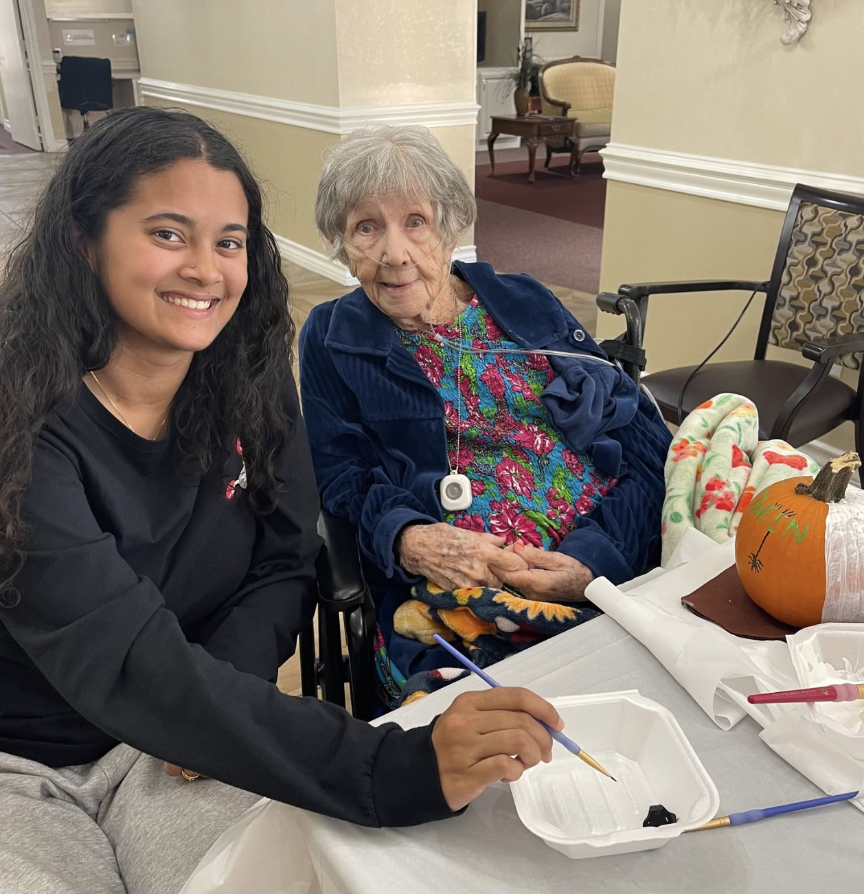Resident and volunteer engaged in an art activity.