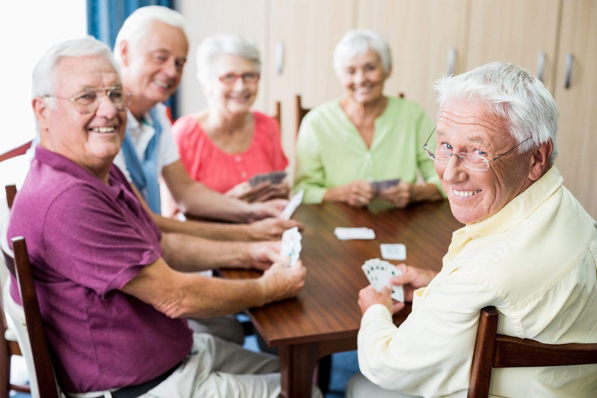 Seniors playing cards together indoors.
