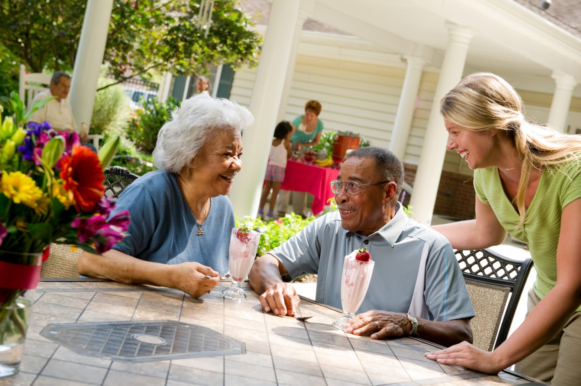 Two seniors enjoying ice cream on a patio