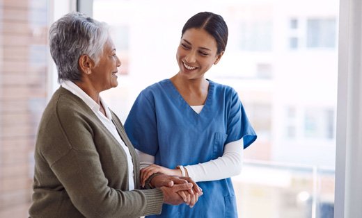 A staff member assisting a resident in a bright interior