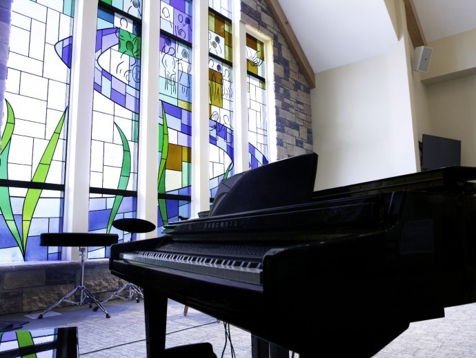 Piano in front of colorful stained glass windows
