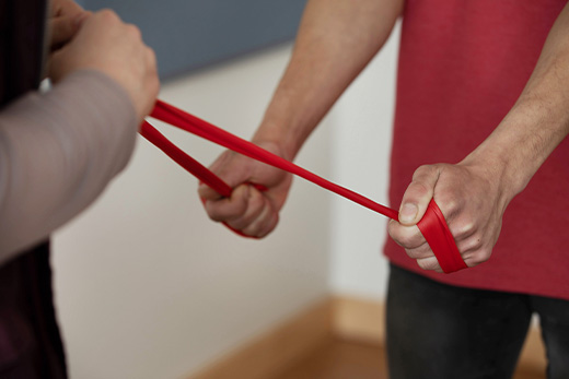 Two people using a resistance band in an exercise session