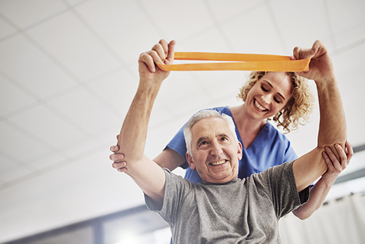Senior resident participating in physical therapy with staff