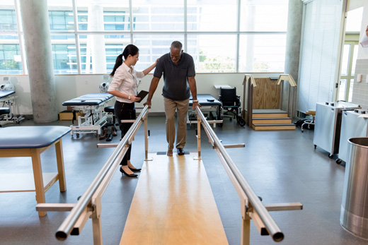 Therapist assisting a resident in a rehabilitation setting
