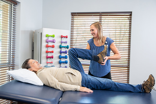 Staff assisting a resident with physical therapy exercises