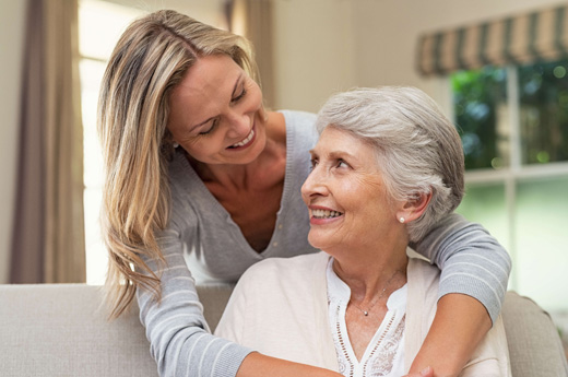 Two women smiling together in a cozy living space