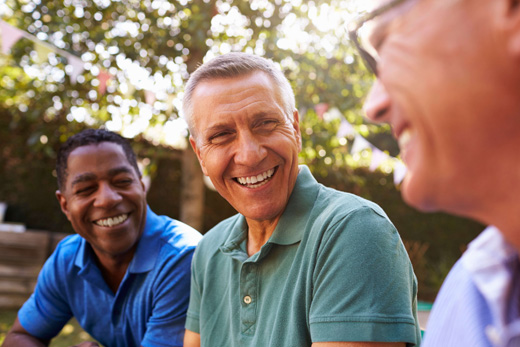 Three men smiling in a garden
