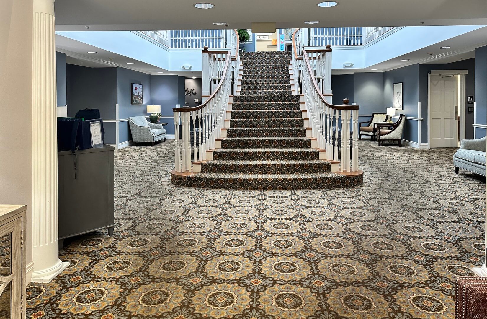 A spacious lobby with a grand staircase and seating areas