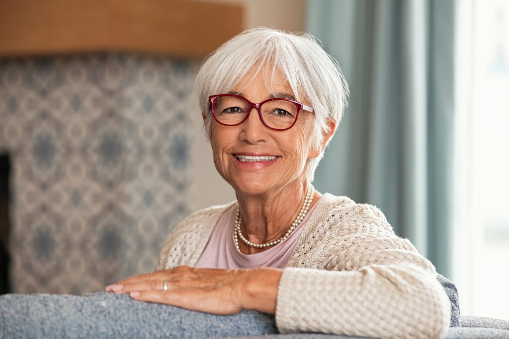 Smiling resident with glasses in a cozy setting