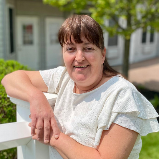 Staff member smiling outside near facility