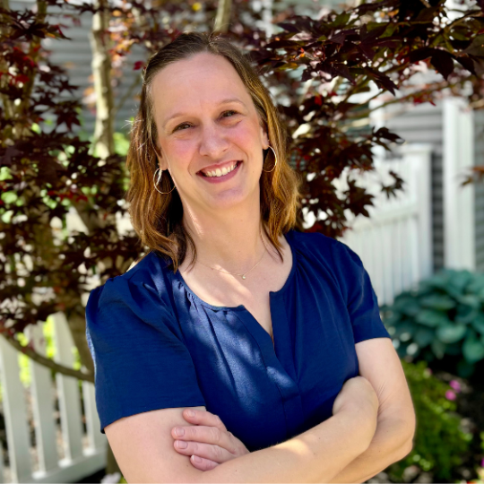 Staff member smiling in a garden area