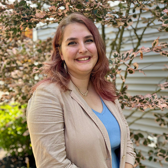 Woman smiling in front of a flowering tree