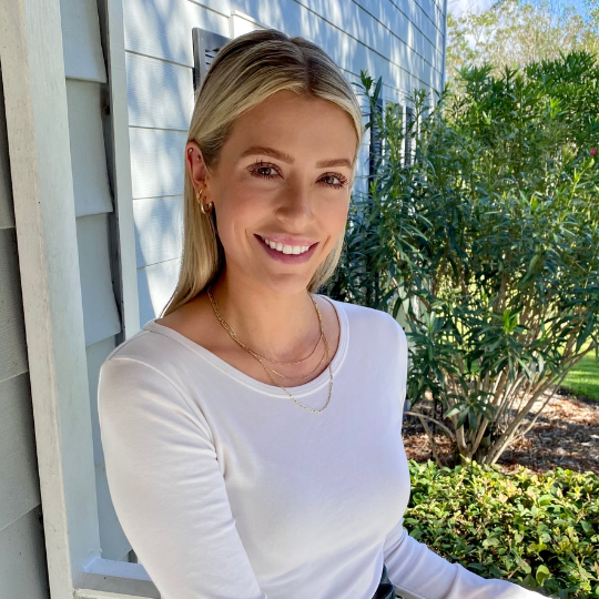A staff member smiling outside a senior living facility