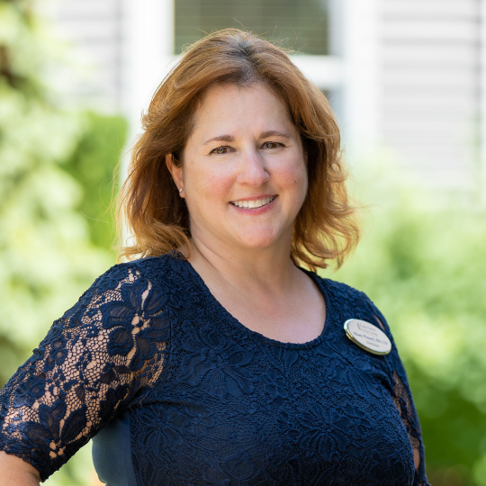 Staff member smiling in a garden setting
