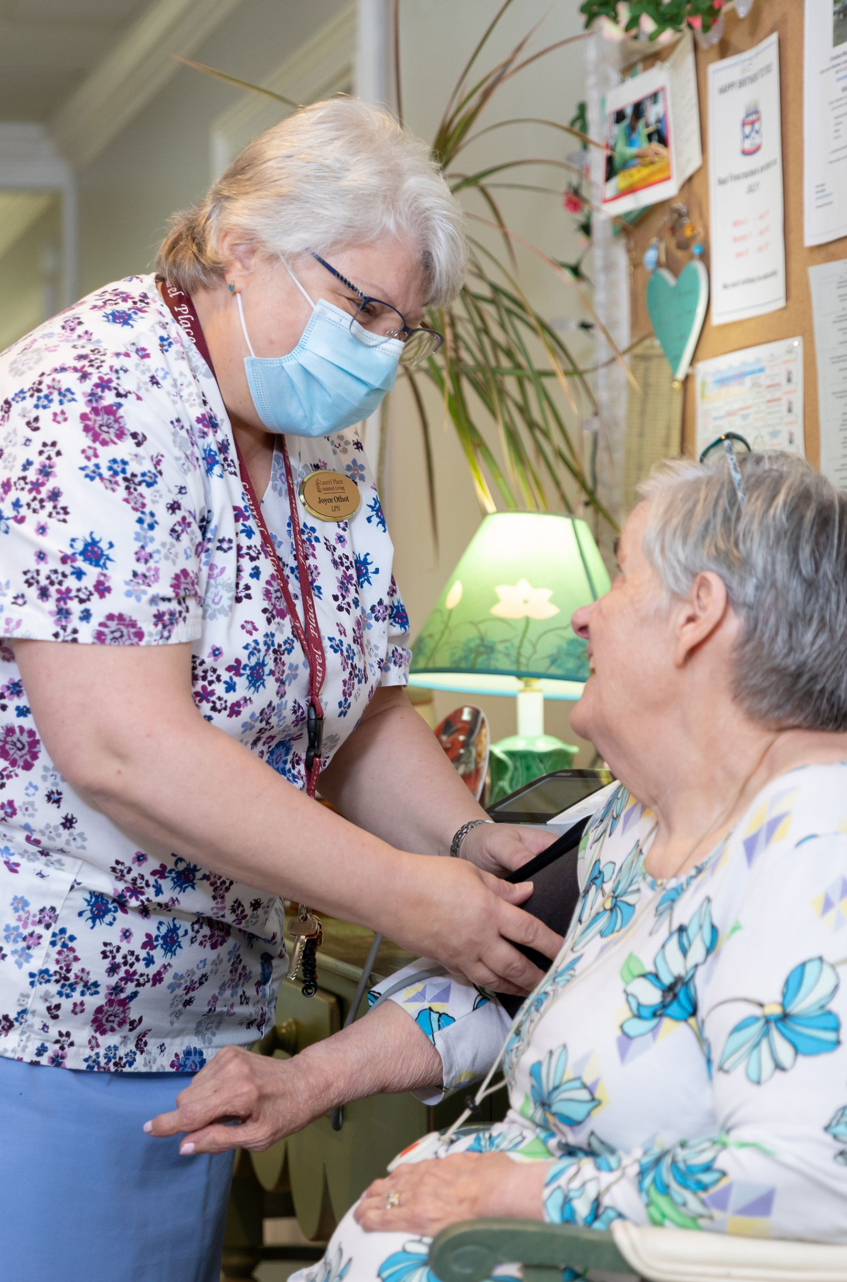 Staff member assisting a resident in a cheerful interior setting