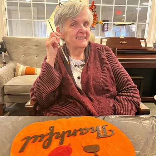 Resident celebrating with autumn decoration at a common area.