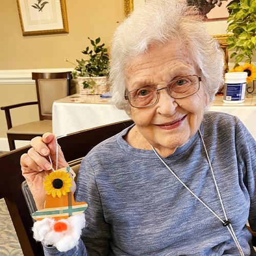 Resident holding a handmade craft in a common area