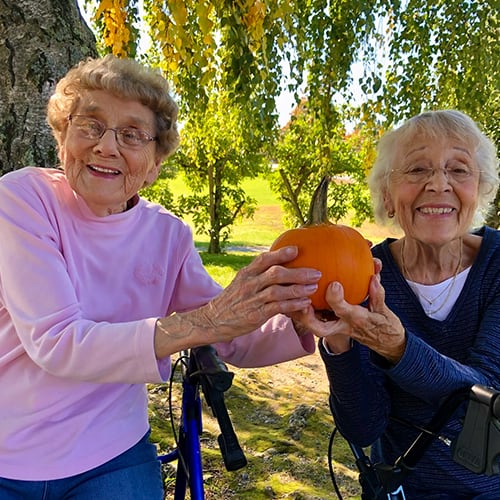 Two residents enjoying a pumpkin outdoors