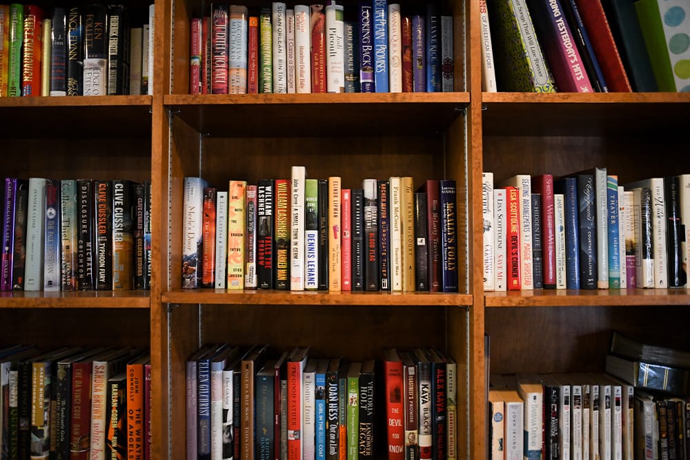 Bookshelves filled with various books in a common area