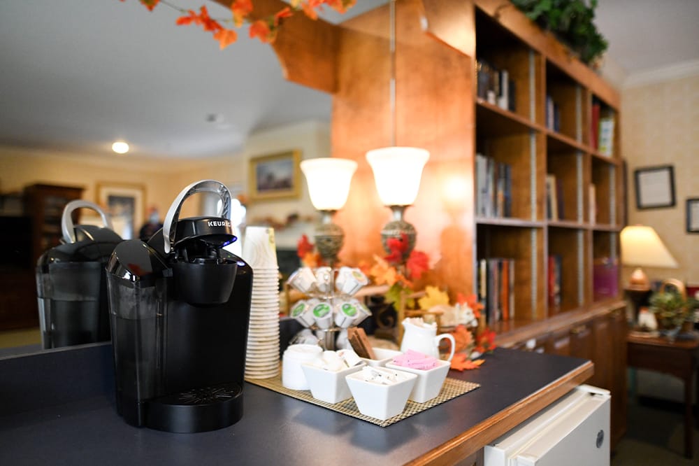 Cozy coffee station in a common area with warm lighting
