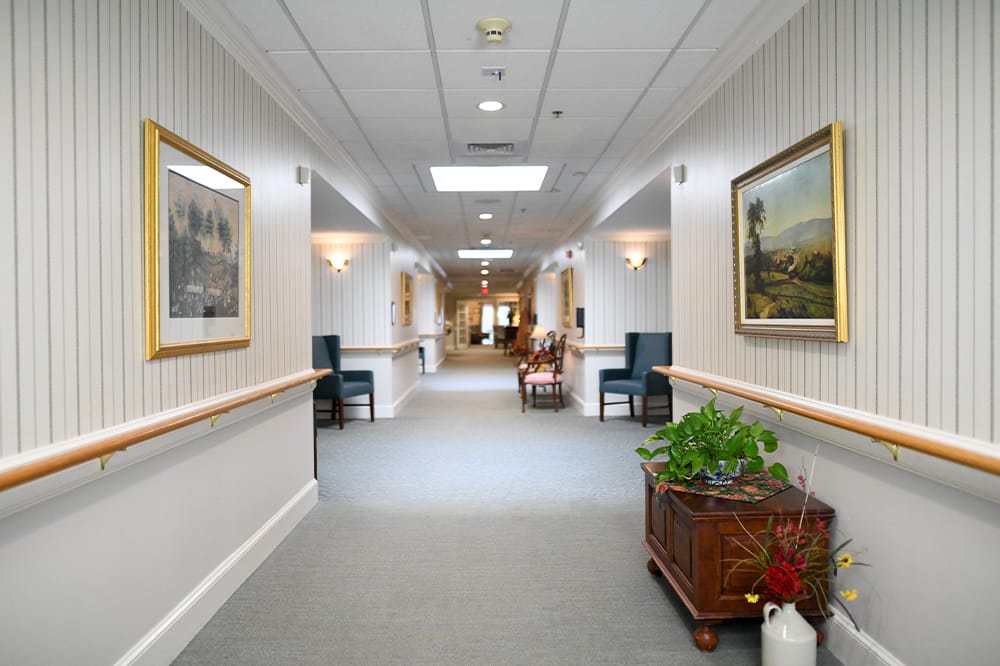 A well-lit hallway with artwork and furniture