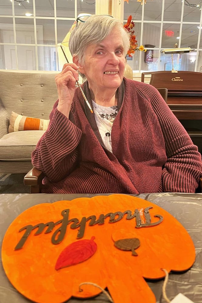 A resident smiling while holding a craft project