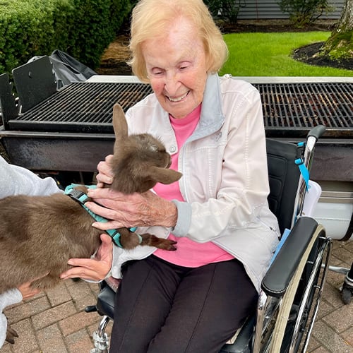 Resident interacting with a small animal outdoors