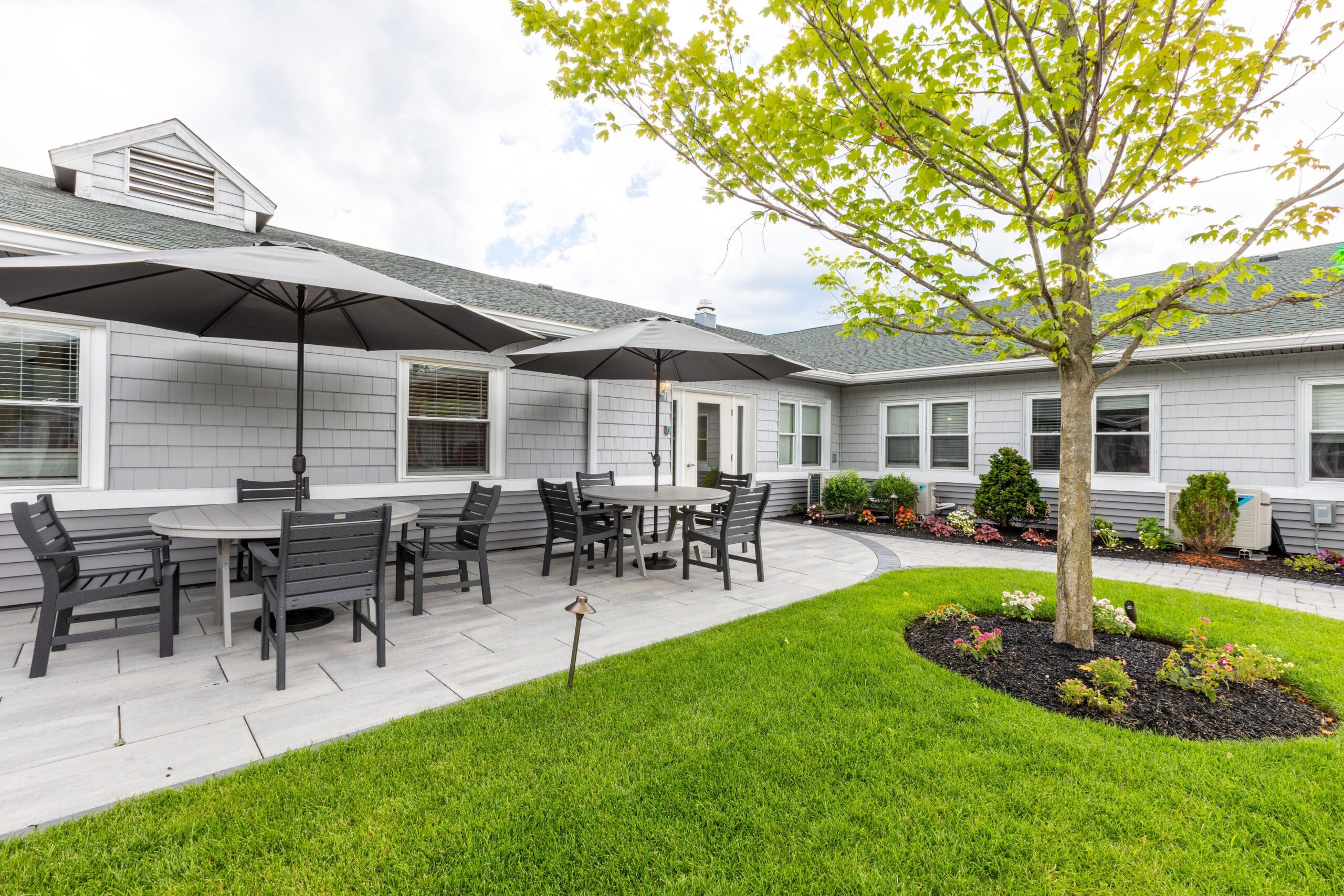 Outdoor seating area with patio umbrellas and garden
