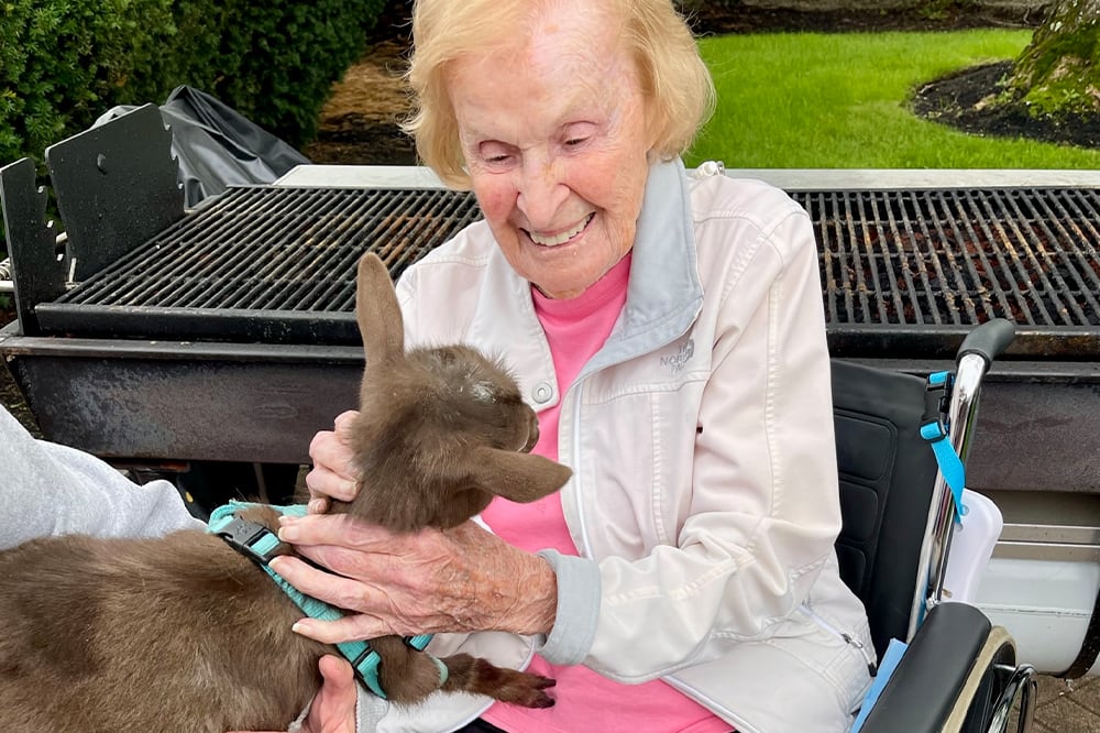 Resident enjoying a visit with a pet goat