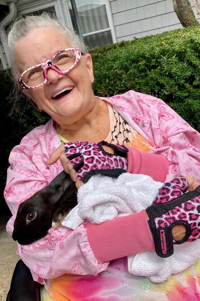 Resident happily holding a rabbit outdoors