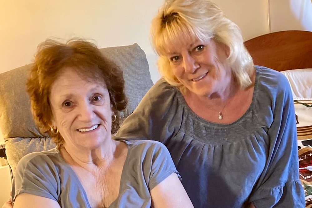 Resident and staff member smiling together